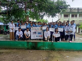 A group photo with students holding the poster of rabies program.