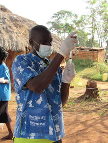 Vaccinator prepares to vaccinate a dog. The Big Fix Uganda.